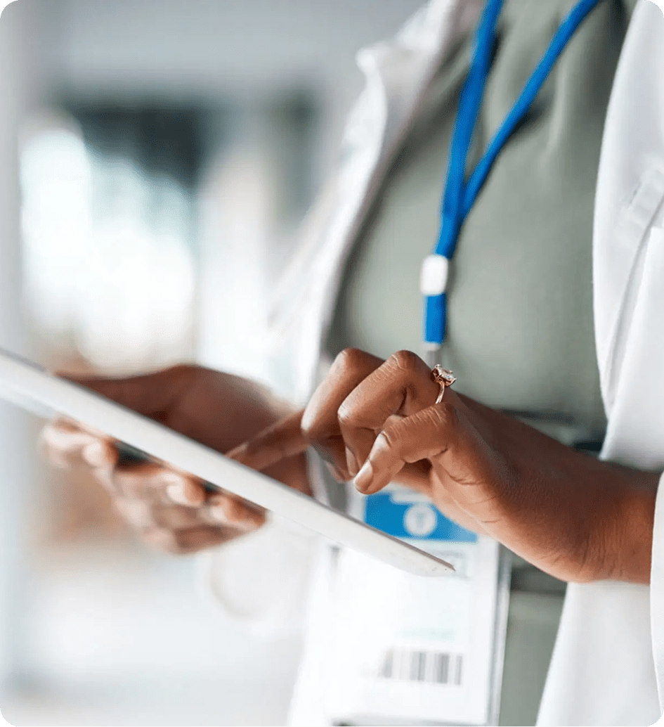 Healthcare professional using a tablet for patient care.