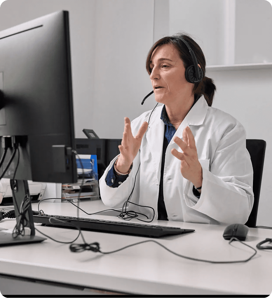 Female doctor consulting a patient via telemedicine with headset and computer.