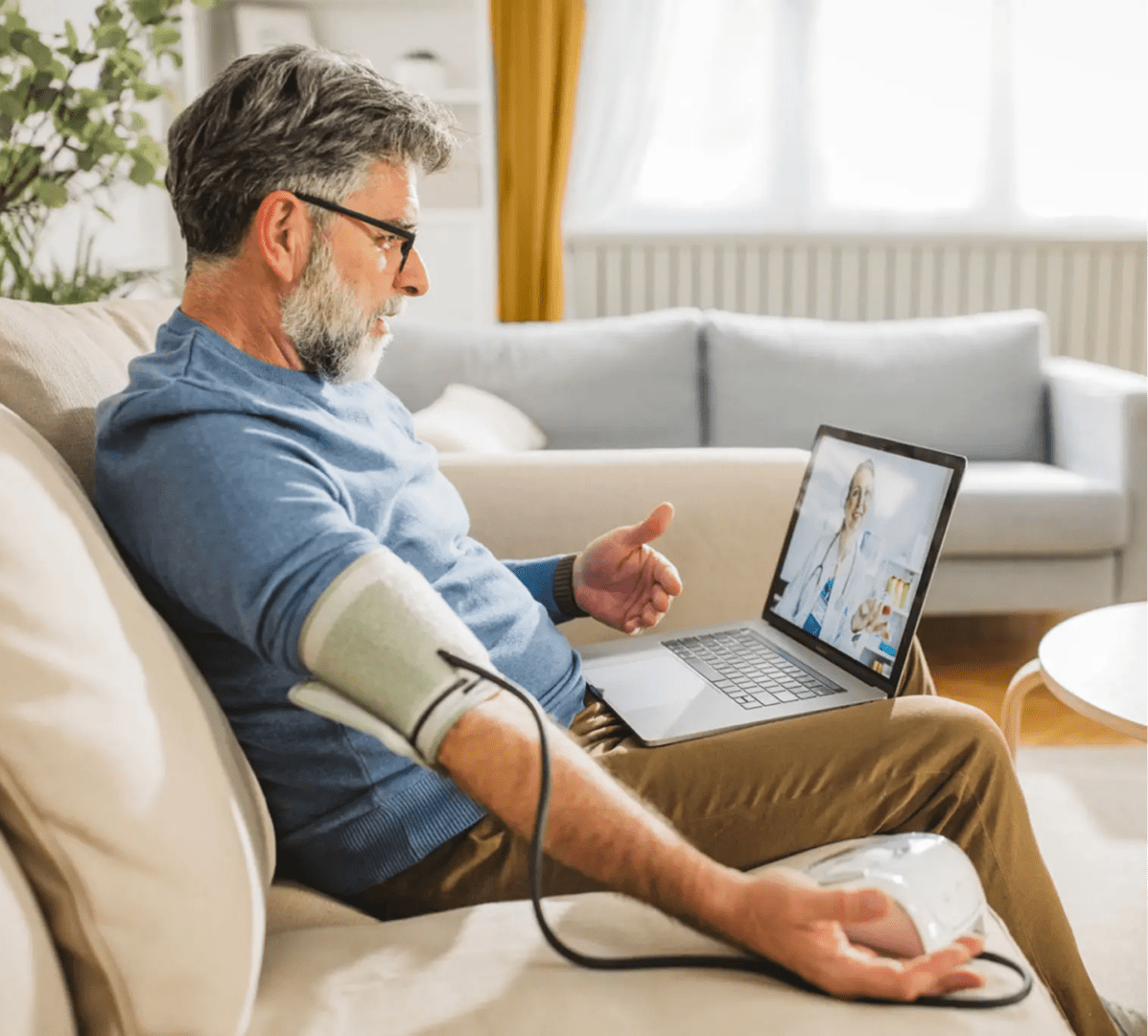 Man checking blood pressure at home with a digital monitor.